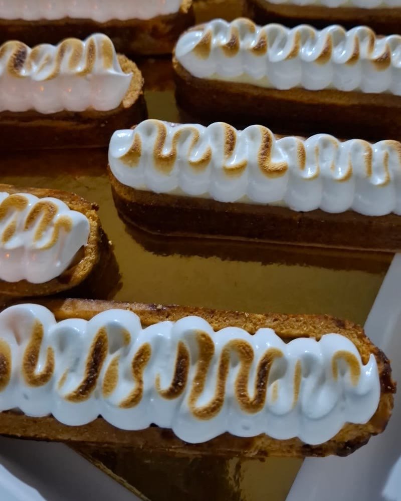Tartelettes meringuées dorées rangées sur un plateau