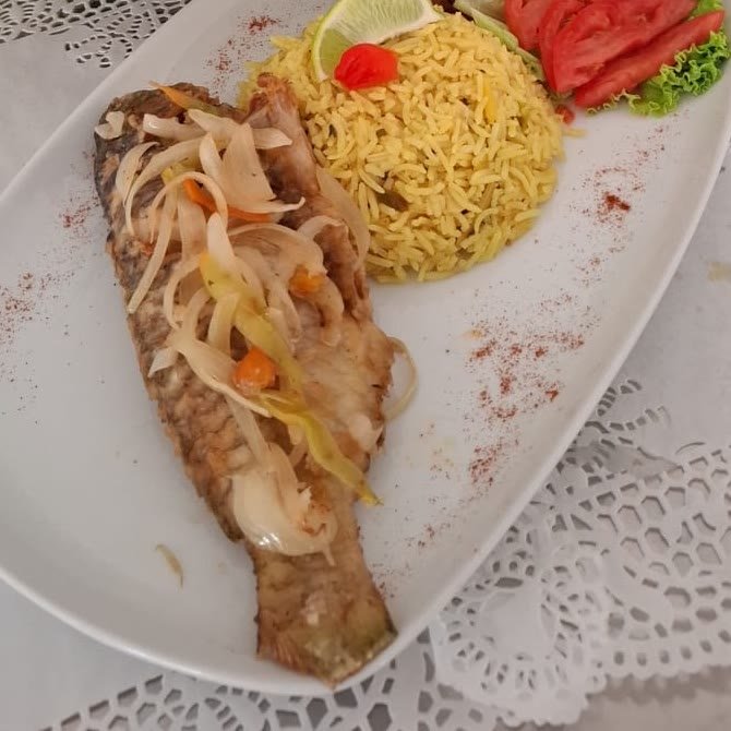 Poisson frit aux oignons servi avec du riz créole et des accras