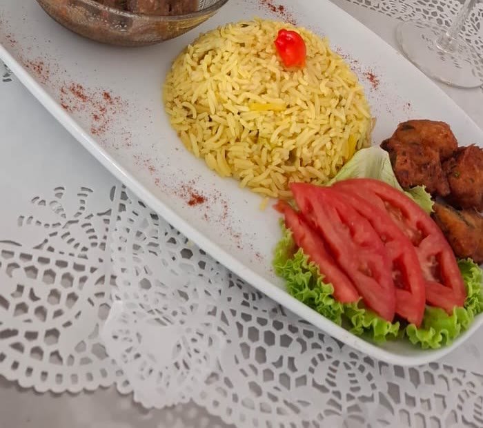 Plateau de riz créole avec ragoût de viande, accras et tomates
