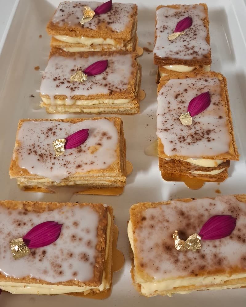 Millefeuilles vanille glacés, décorés d'un pétale fuchsia et d'une feuille d'or